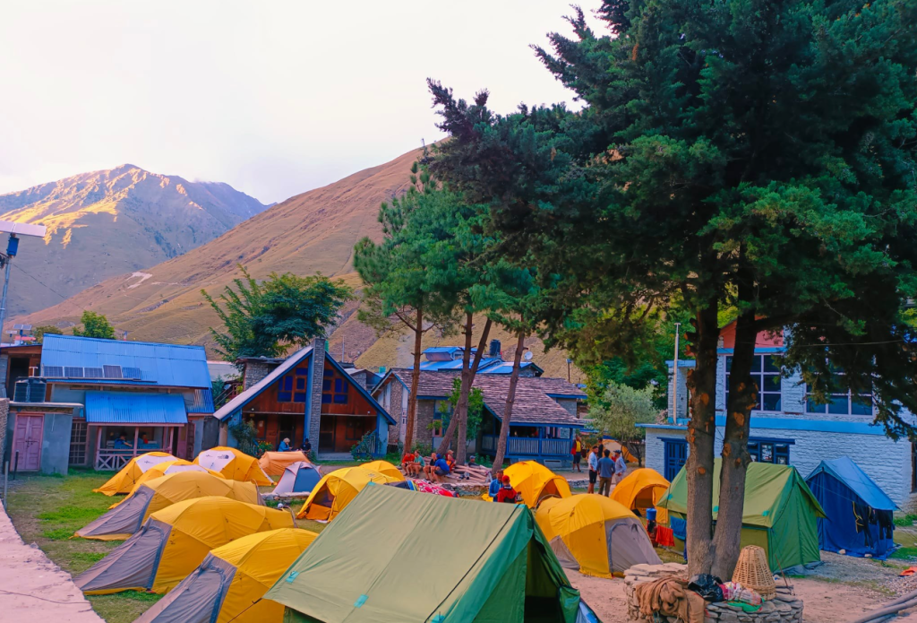 Bright yellow and orange tents set up in a high-altitude Himalayan base camp.