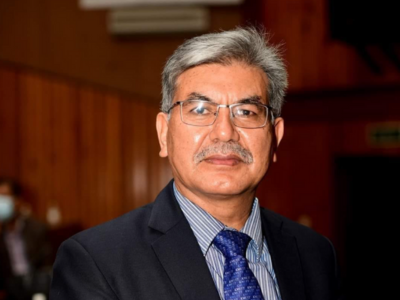 Formal portrait of a senior Nepali official in a suit and tie.